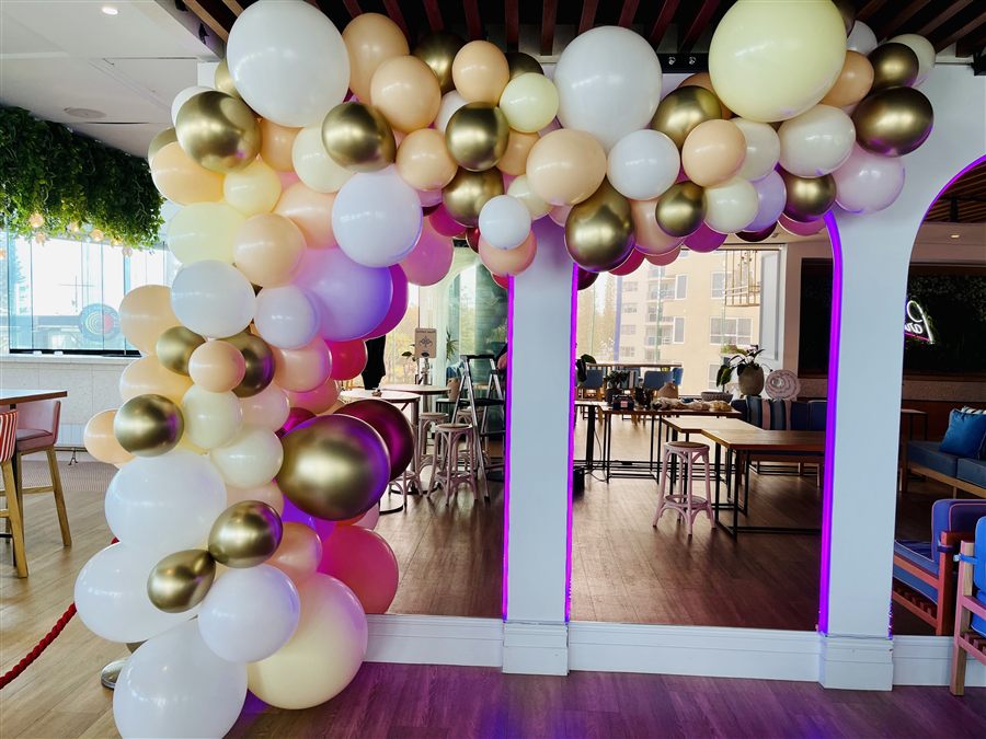 White, cream and gold balloon garland over an archway